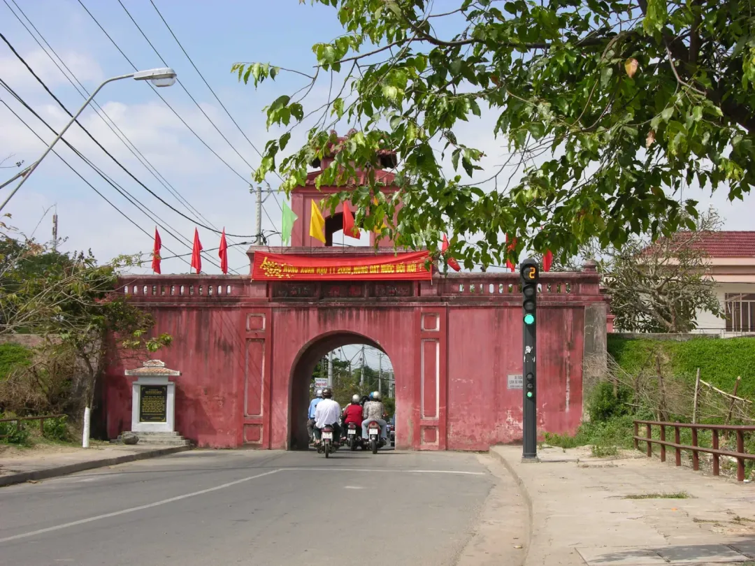 The east gate of Dien Khanh citadel, red brick with flags on the tower